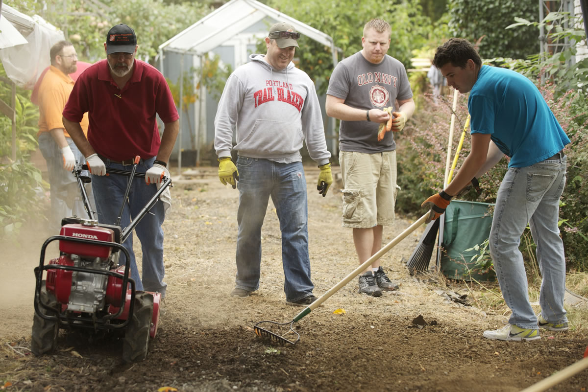 Home Depot volunteers work on military veteran Clyde Kment's driveway Tuesday.