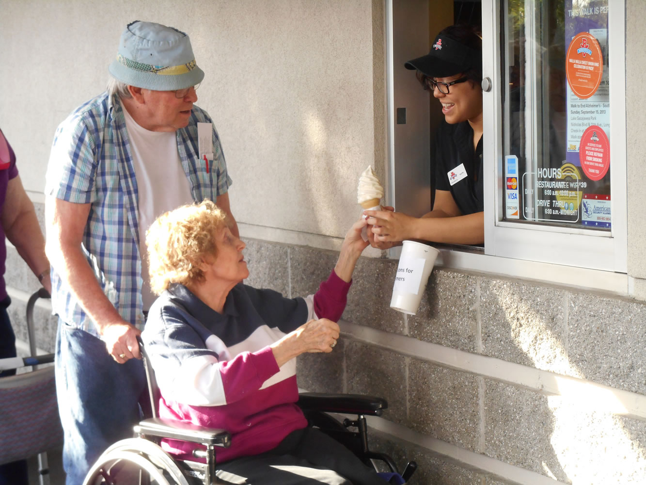 Village at Fisher's Landing: Fisher's Landing Burgerville employee Karlie Rodriguez hands an ice cream cone to Joyce Ake as the Emeritus at Fisher's Landing resident's boyfriend Seley Moore stands behind her. The Aug.