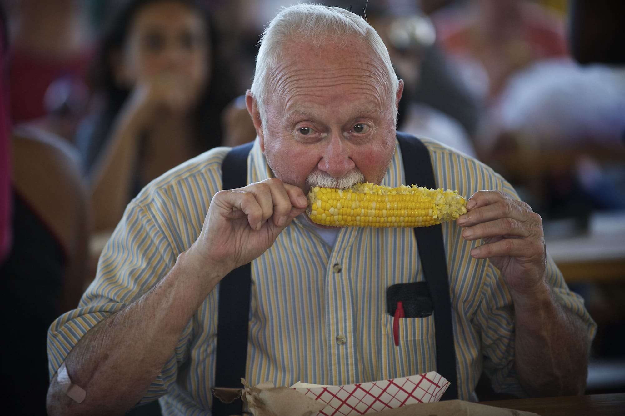 Bud Webster, 79, of La Center bites in to a cob of corn Saturday at the Sausage Fest at St. Joseph Catholic School.