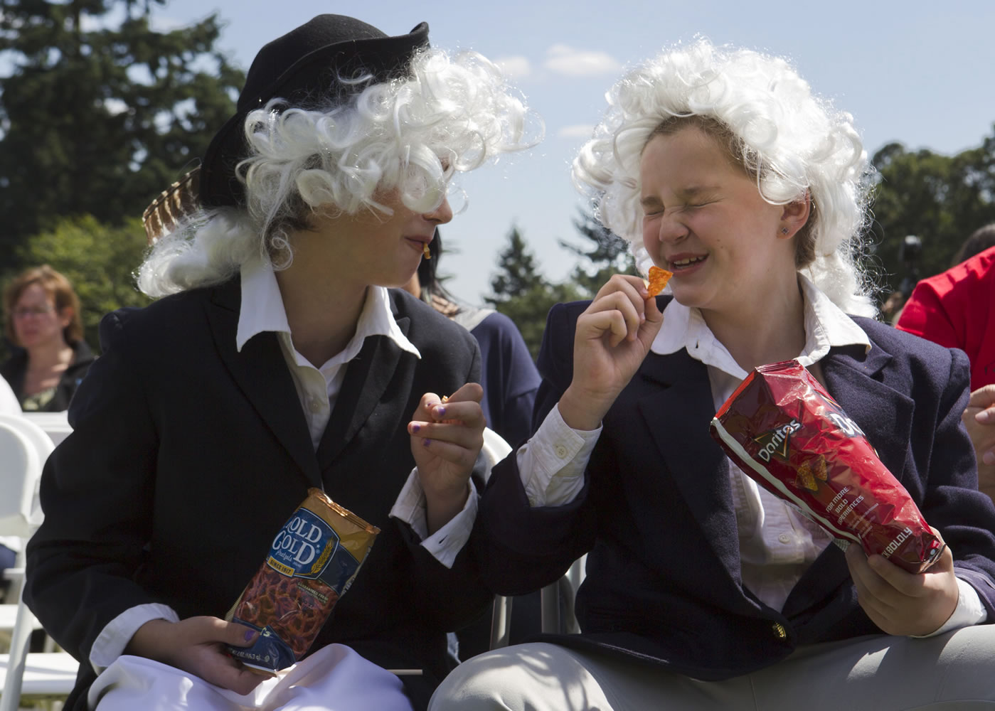 Emalee Weaver, left, draws a laugh from Camryn Jurcich during Flag Day at Fort Vancouver. Weaver, dressed as Robert Livingston, and Jurcich, portraying John Adams, helped give a history lesson on the flag during Friday's festivities.