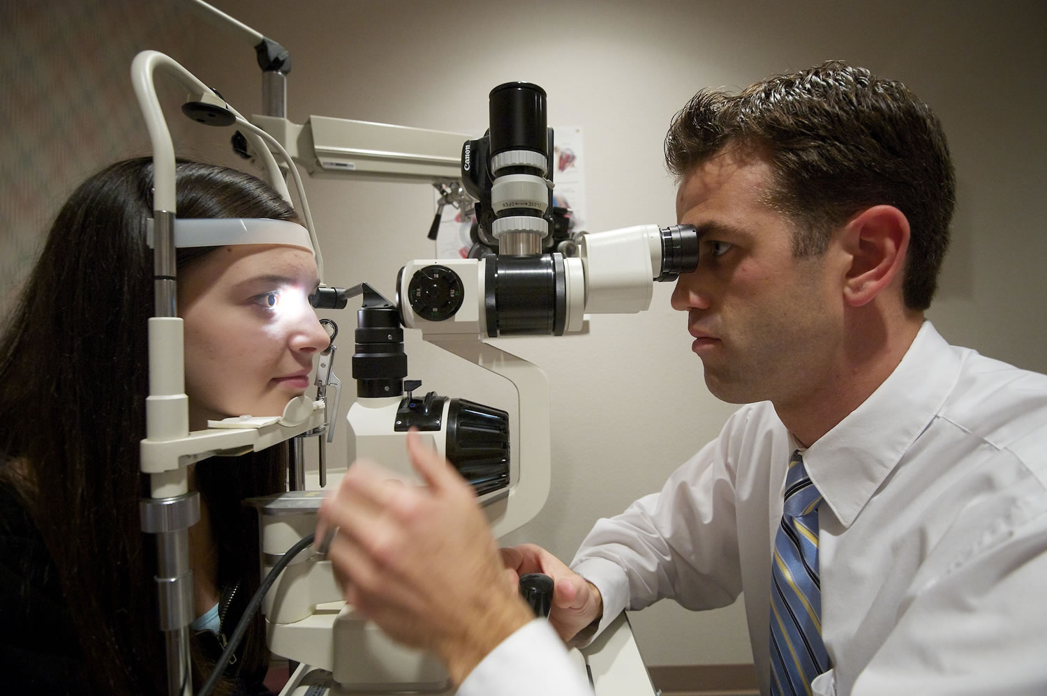 Brett Richardson examines Marina Kondratyuk, 15, during a routine eye exam at the Richardson Eye and Contact Lens Clinic in Vancouver. Below, Todd Richardson uses a new scanning laser machine to view the retina image and other parts of an eye.