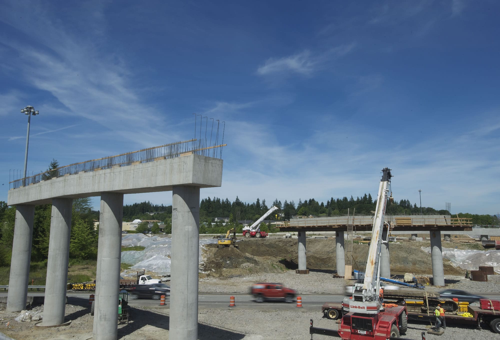 Crews move a crane, in pieces, into place near southbound Interstate 5 in preparation for this weekend's girder installation.
