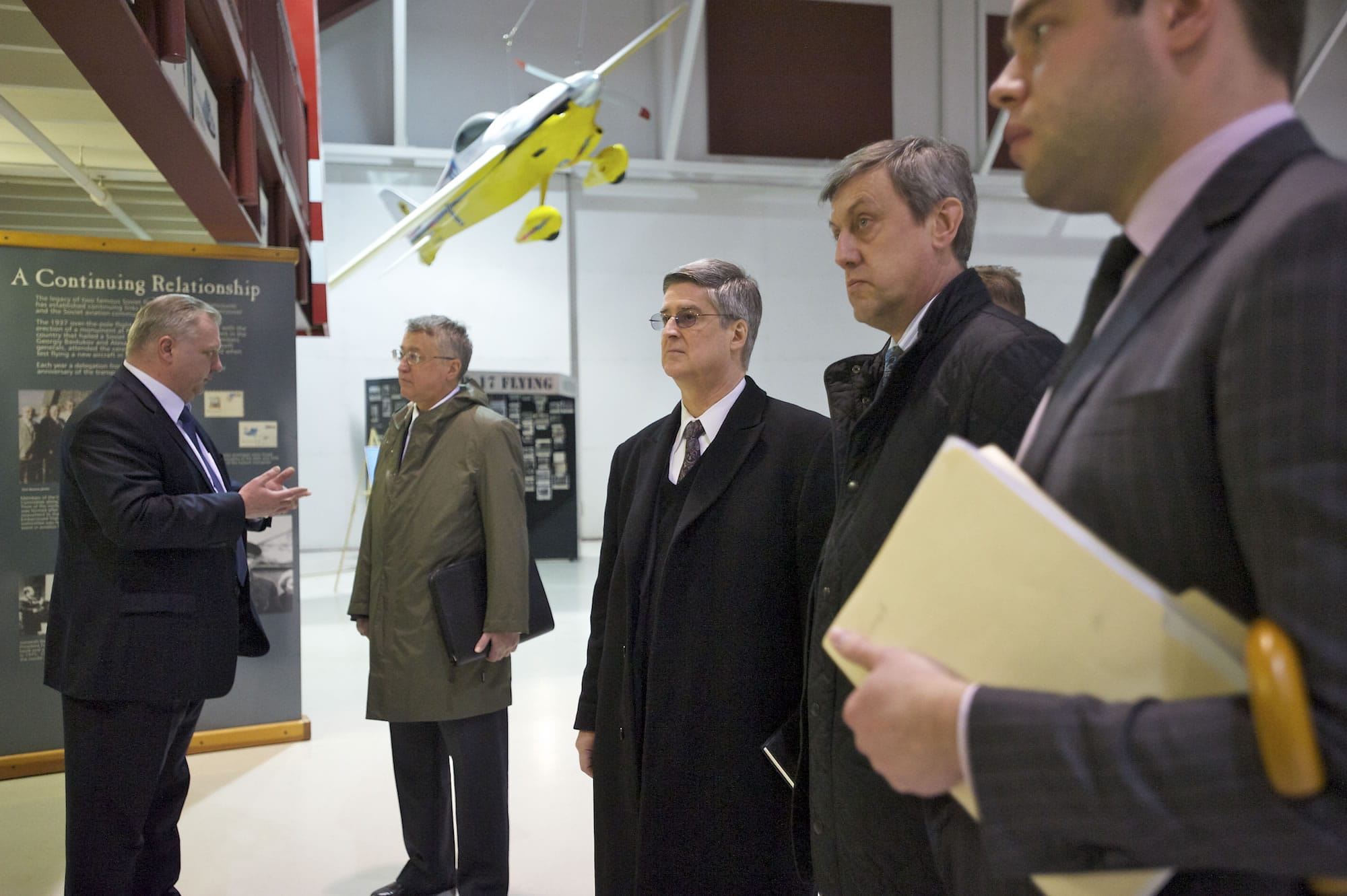 Valery Chkalov, left, grandson and namesake of famed Soviet aviator Valery Chkalov, speaks to Vladimir Vinokurov, Russia's consul general in San Francisco, while Doug Lasher looks at trans-polar flight panels with Andrey Yushmanov, Russian consul general in Seattle and his head of protocol, Evgeny Uspenskiy, during Wednesday's visit to Pearson Air Museum.