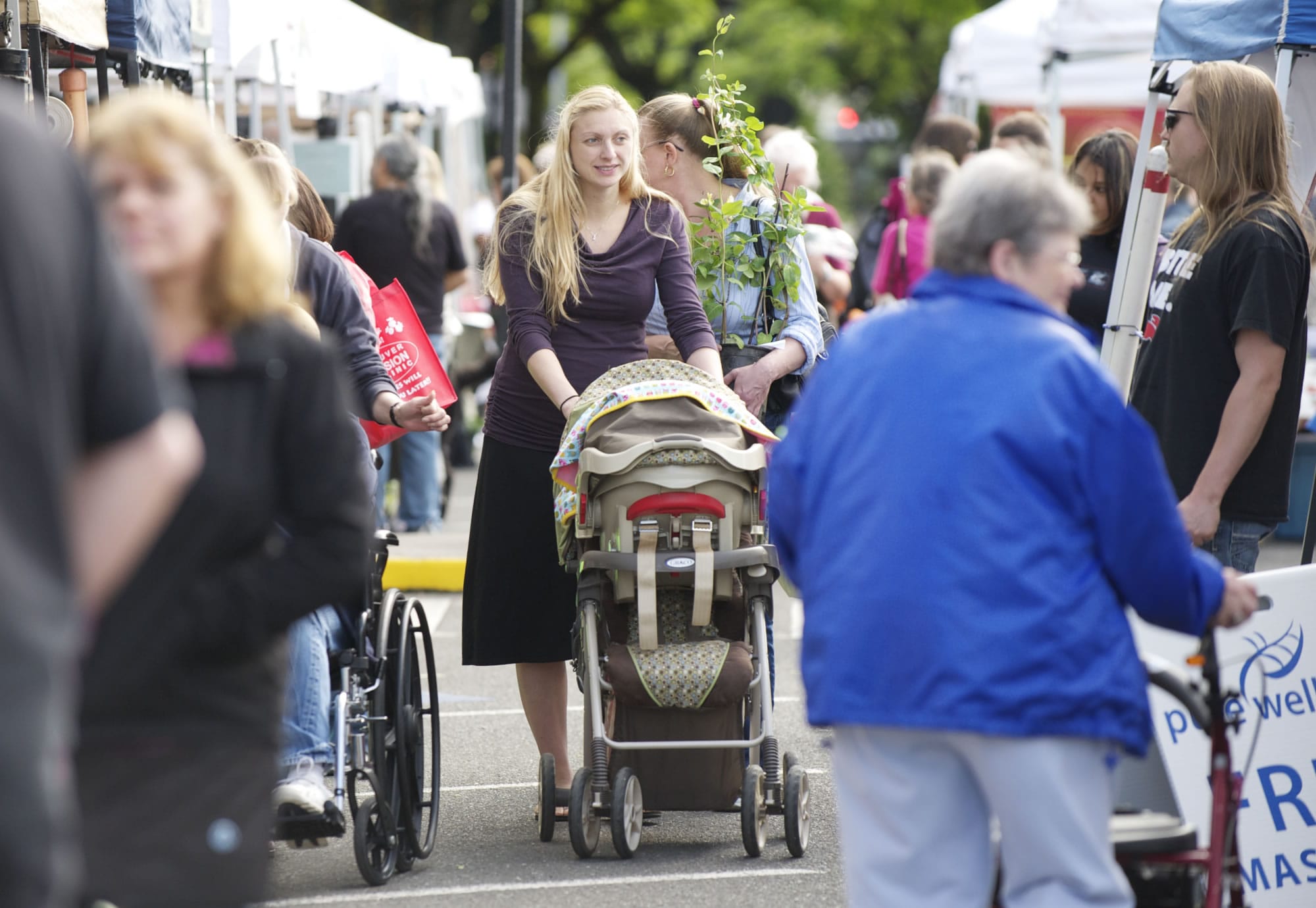 Jennifer Burian pushes her 7-day-old baby, Lara, in a stroller as she shops at the Camas Farmer's Market on Wednesday.