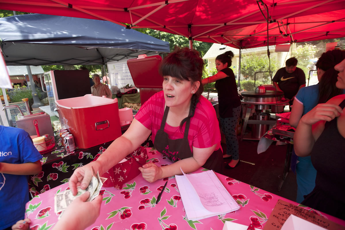 Kristen Ah Yek of Kristen's Sweet Delights waits on customers Saturday at the Vancouver Farmers Market.