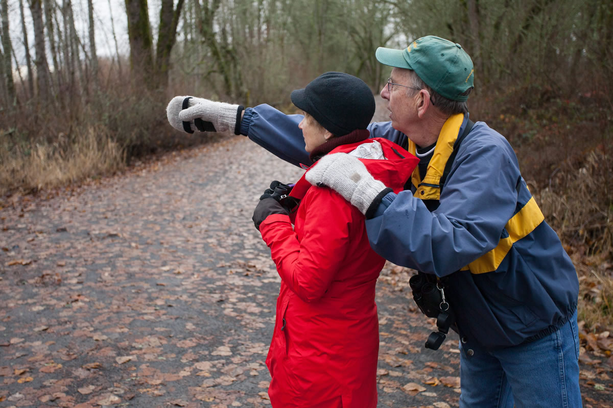 Arden Hagen, right, points out birds at Vancouver Lake Park to Jan Verrinder while participating in the annual Christmas Bird Count on Sunday.