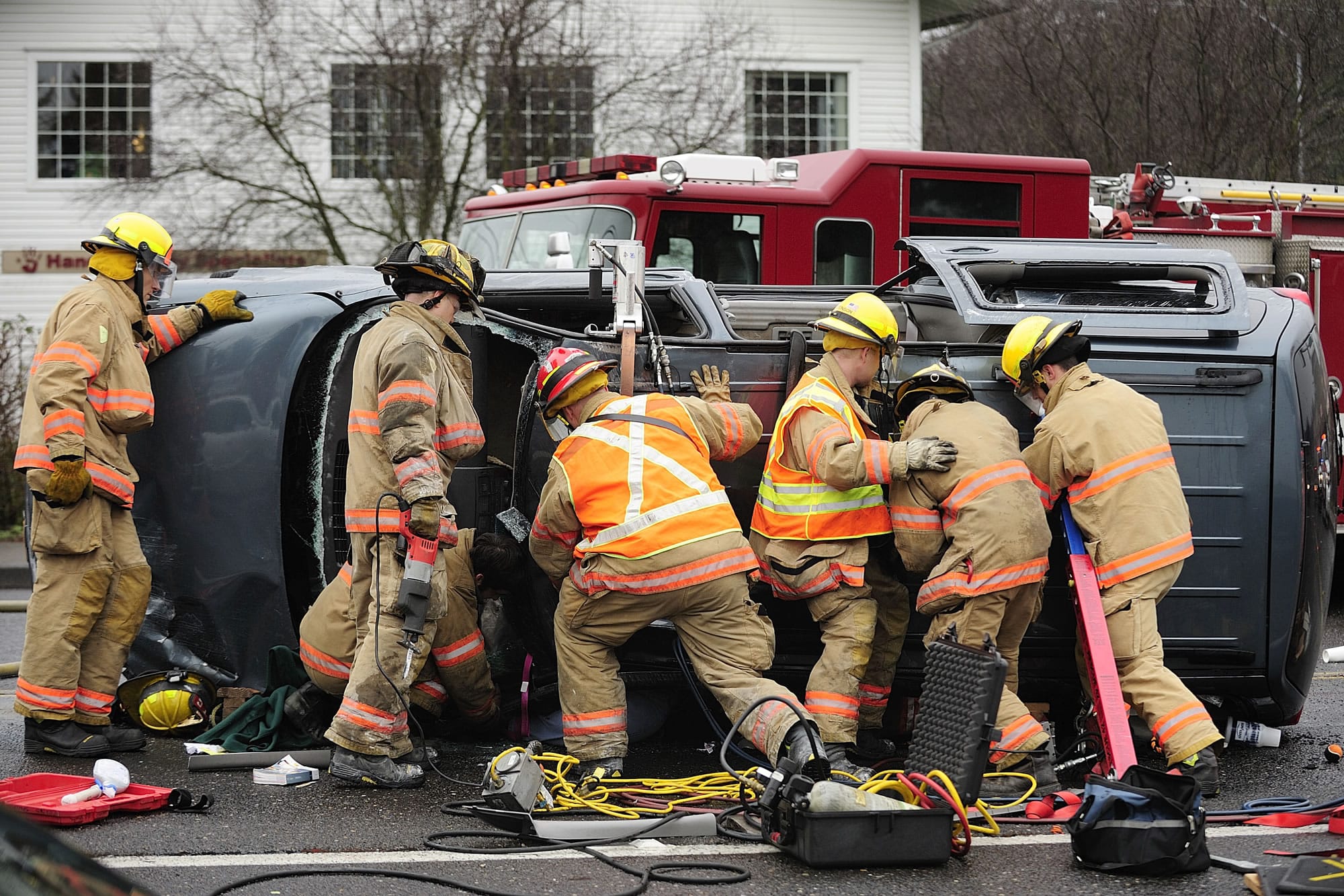 Firefighters with the Vancouver Fire Department work to rescue a woman trapped in an overturned van after a two-vehicle accident  at the intersection of Fourth Plain Boulevard and Vancouver Mall Drive on  Jan.