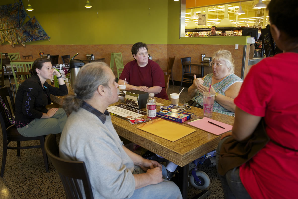 A small group, from left, Jenny Kidd, Kerry Giovanni, Sheryl Ingoe, Beverly Smith and Anjela Ford, all of Vancouver, communicate using American Sign Language during a monthly Deaf Coffee Night Monday at New Seasons Market in Fisher's Landing.