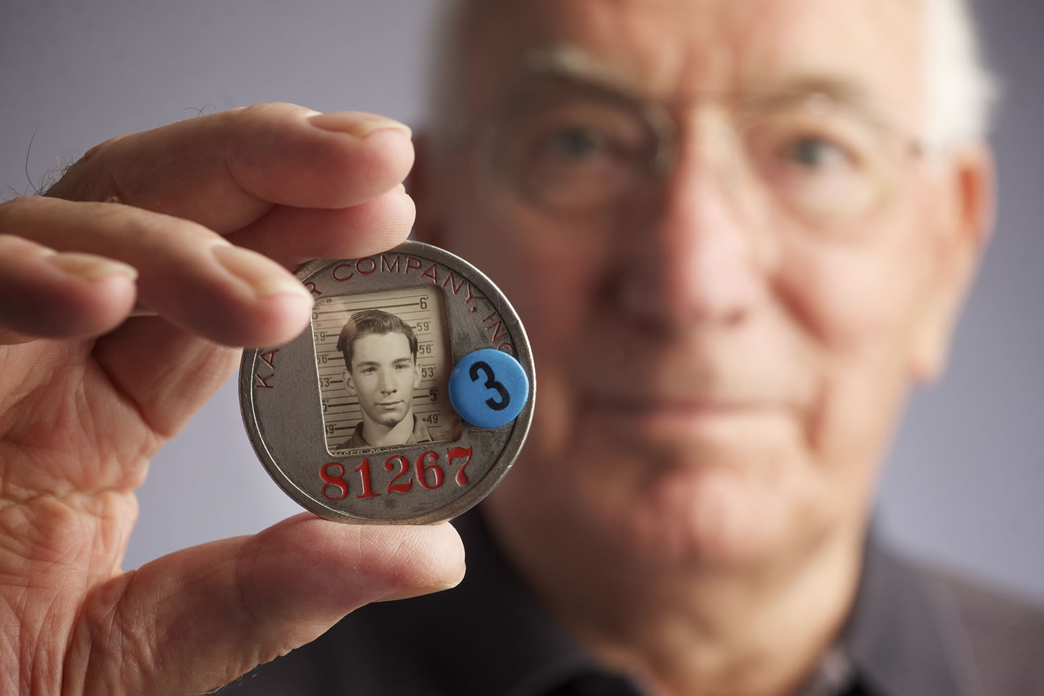Harry Hendricks holds a Kaiser shipyard ID badge with a photo taken when Harry was a 14-year-old shipyard worker. Hendricks lied about his age so he could get a job at the shipyard. The photo was taken Aug.