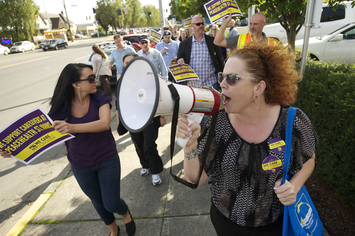 Shannon A. Walker, president of the Southwest Washington Central Labor Council, leads a group of Service Employees International Union Local 49 supporters during a rally at PeaceHealth St. John Medical Center in Longview. The union, which represents 460 hospital workers at St.