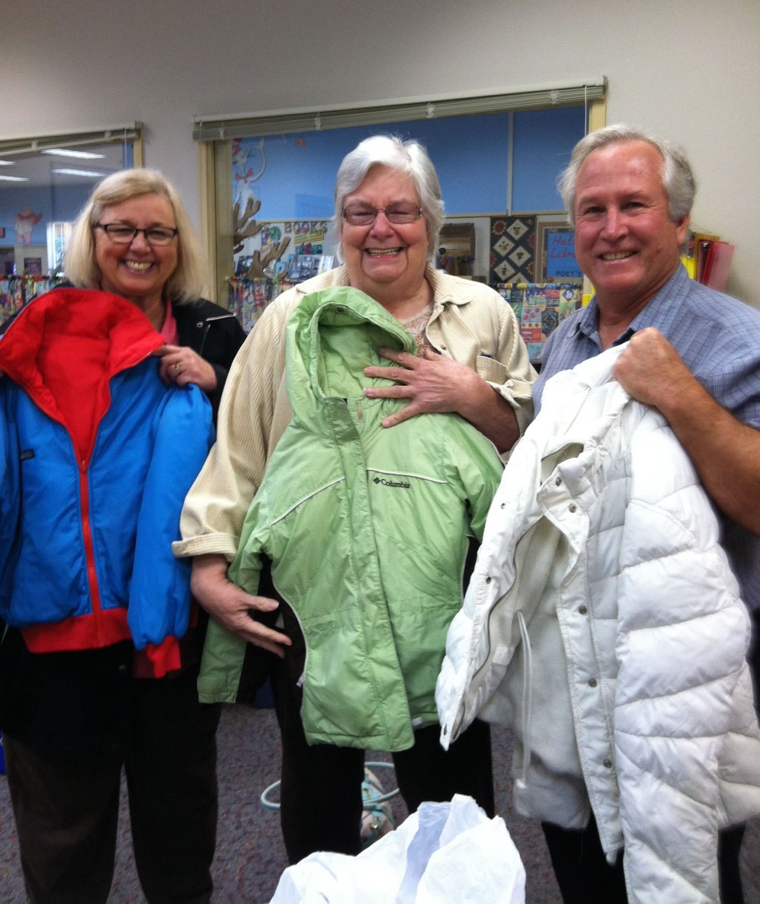Washougal: Kathy Huff, left, Stephanie Welch and Gary Welch display some of the new and nearly new coats the congregation of The Calling Church donated for students in need at Hathaway Elementary School.