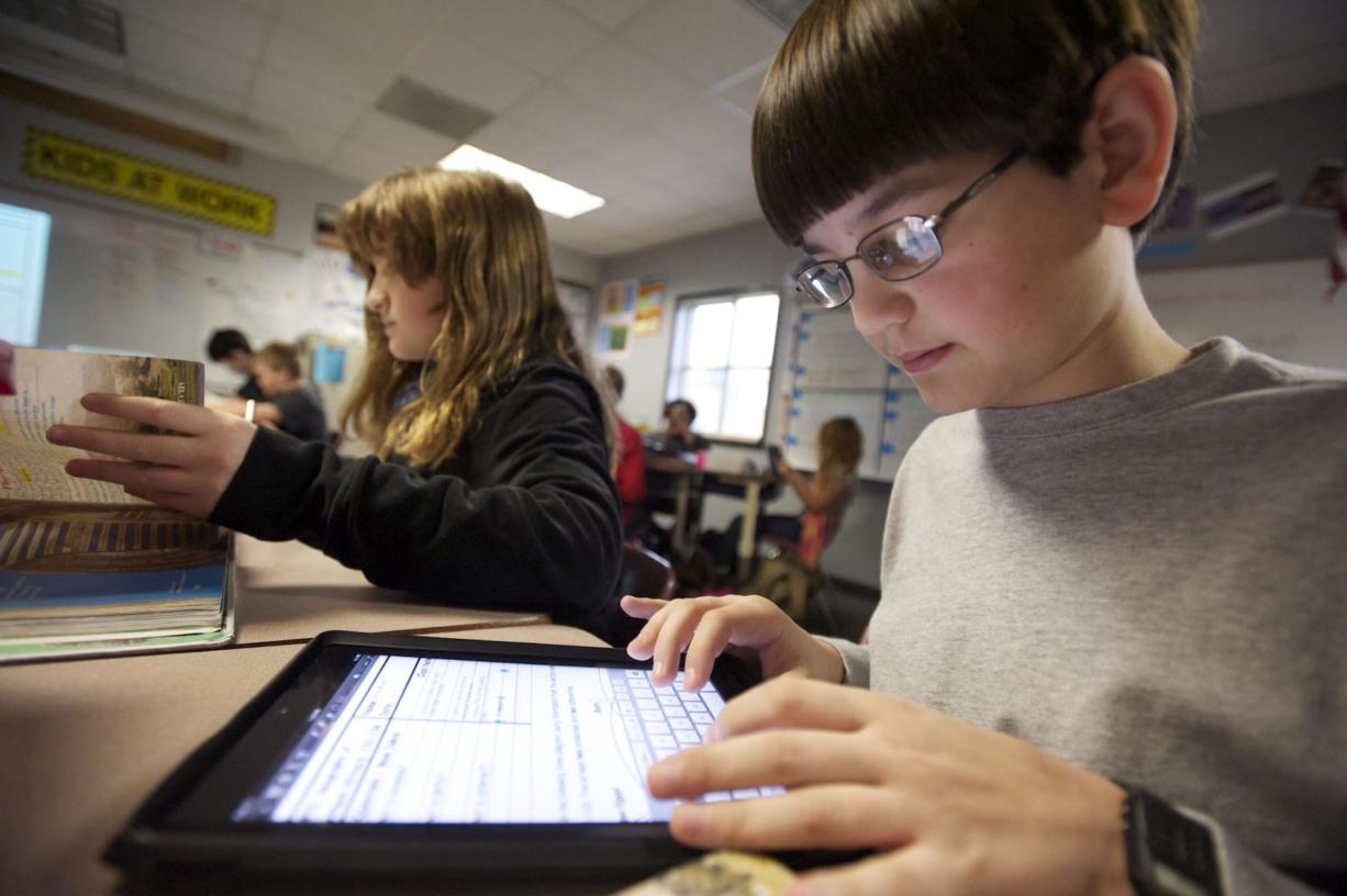Trevor Bryant uses an iPad in Monica Hughey's sixth grade class at McLoughlin Middle School.