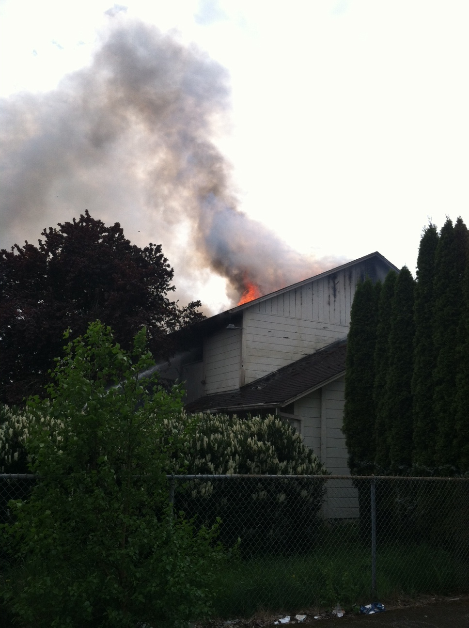 Flames burn through the roof of a vacant duplex on Northeast 85th Avenue in Vancouver's Ogden neighborhood.