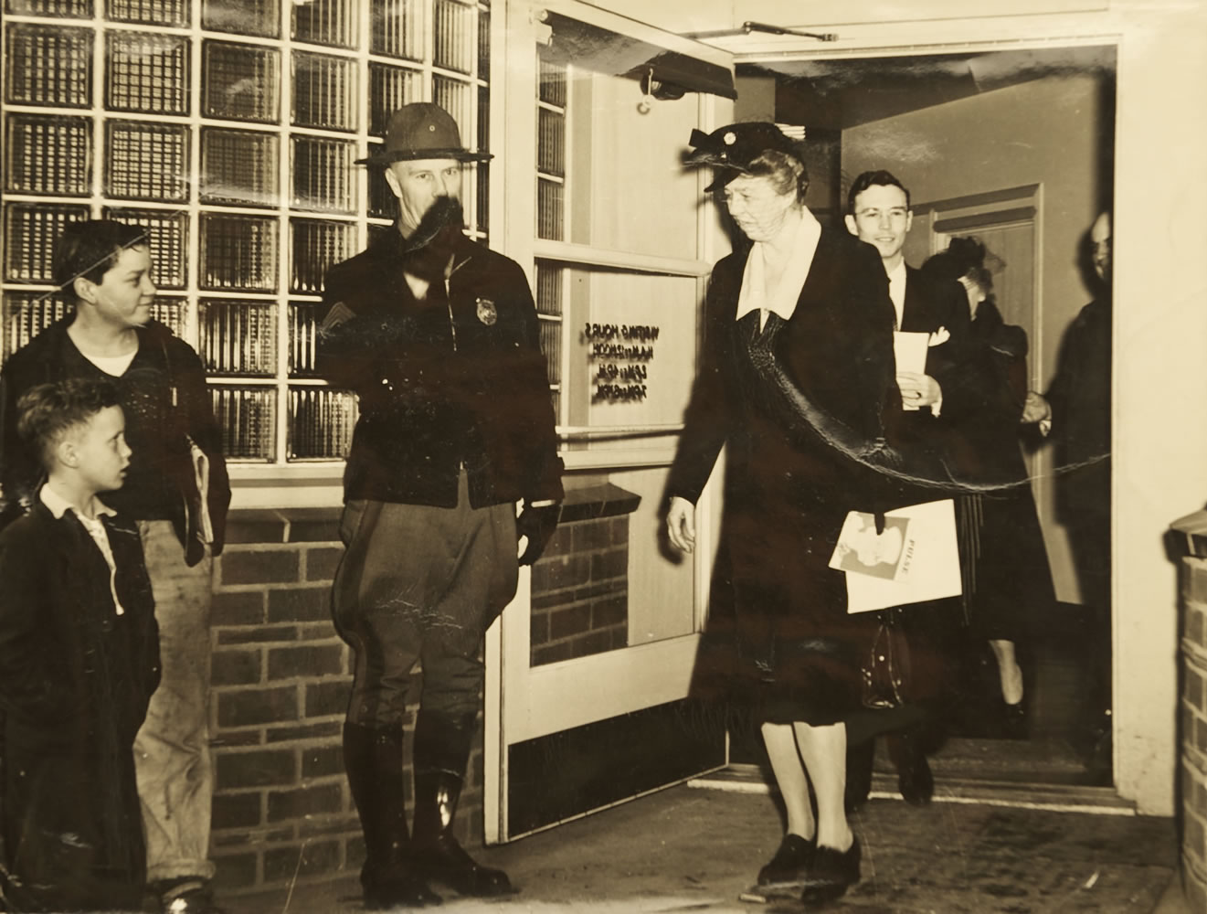 Mel Jackson, lower left, as an 8-year-old boy in 1943 greeting first lady Eleanor Roosevelt as she is escorted from the shipyard hospital.