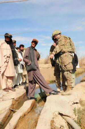 North Image: U.S. Army Capt. Jude Mazzotta, from Vancouver, discusses a hydroelectric power plant system during a Dec. 6 assessment visit to Kawri, Afghanistan. A 22-year-old contractor, Shafiqullah, center, built the system that provides power to 25 families in the remote village.