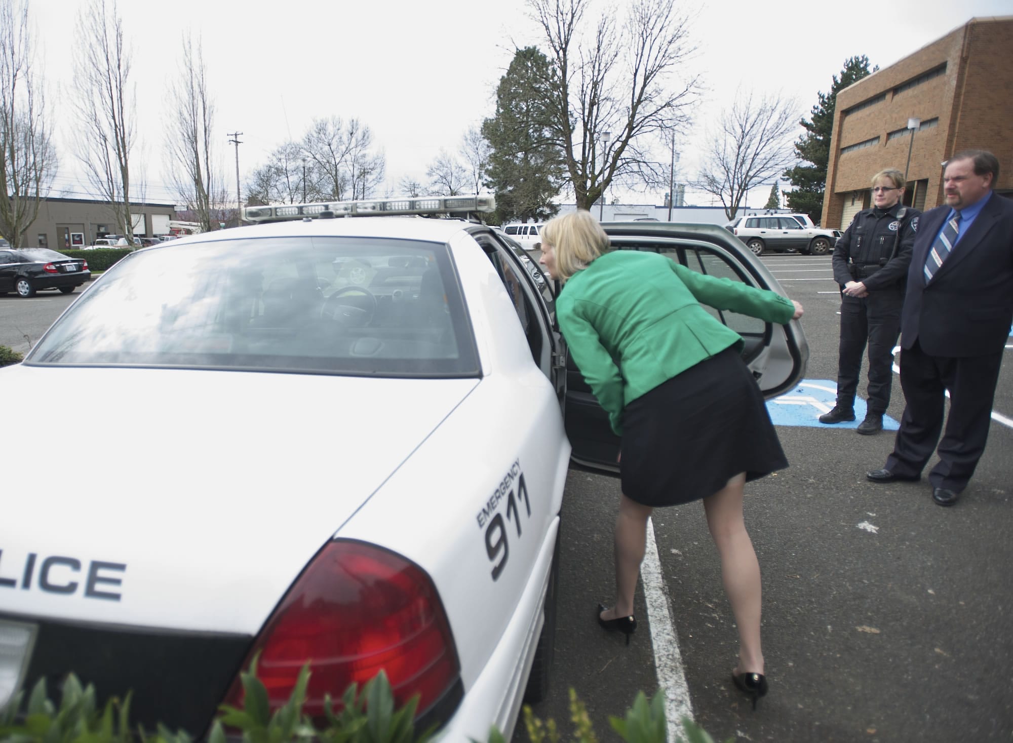 Clark County District Judge Sonya Langsdorf examines the inside of the patrol car Thursday, where former Washougal police Officer Robert Ritchie, right, allegedly assaulted a mentally ill man on July 1.