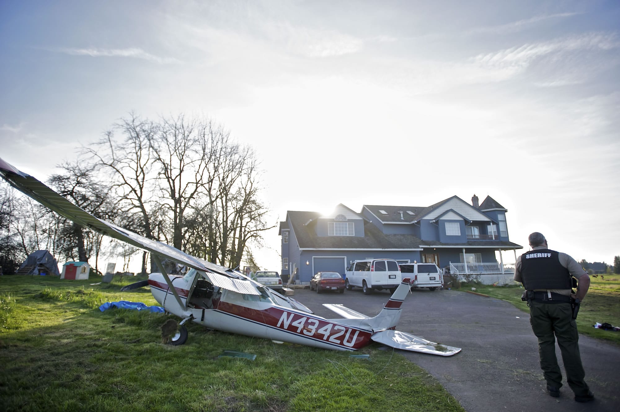 A Cessna 150 sits near the Brush Prairie home of Mark and Angela Congdon, where it crashed while trying to land at Brush Prairie Aerodrome about 5:15 p.m.