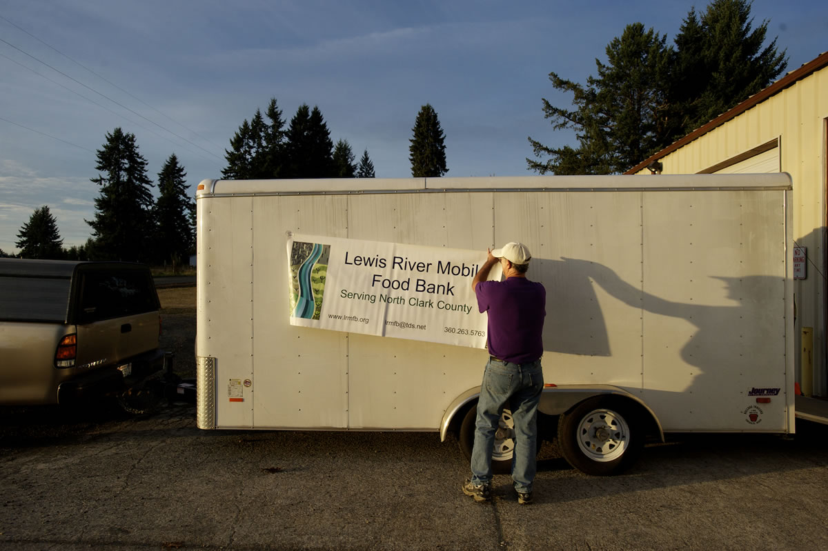 Lewis River Mobile Food Bank volunteer Wayne Howell readies the organization's trailer for clients on the evening of Oct. 17 at a pilot location on 41st Street in the La Center area.
