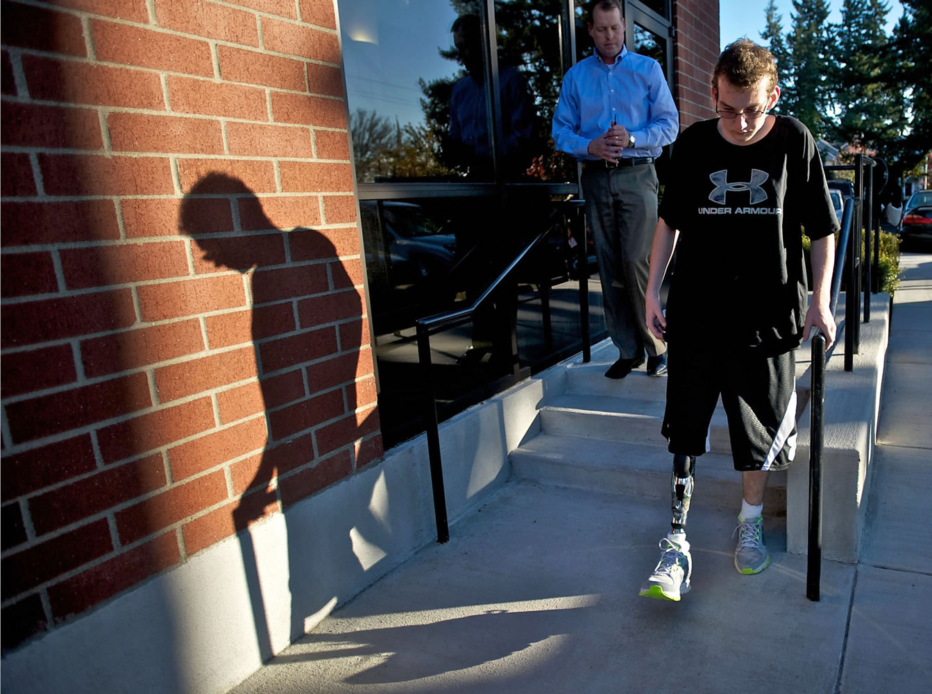 Justin Carey, who lost his leg after being struck by a car as he waited for the school bus, practices walking stairs Monday afternoon with his new prosthetic leg outside of Evergreen Prosthetics &amp; Orthotics.
