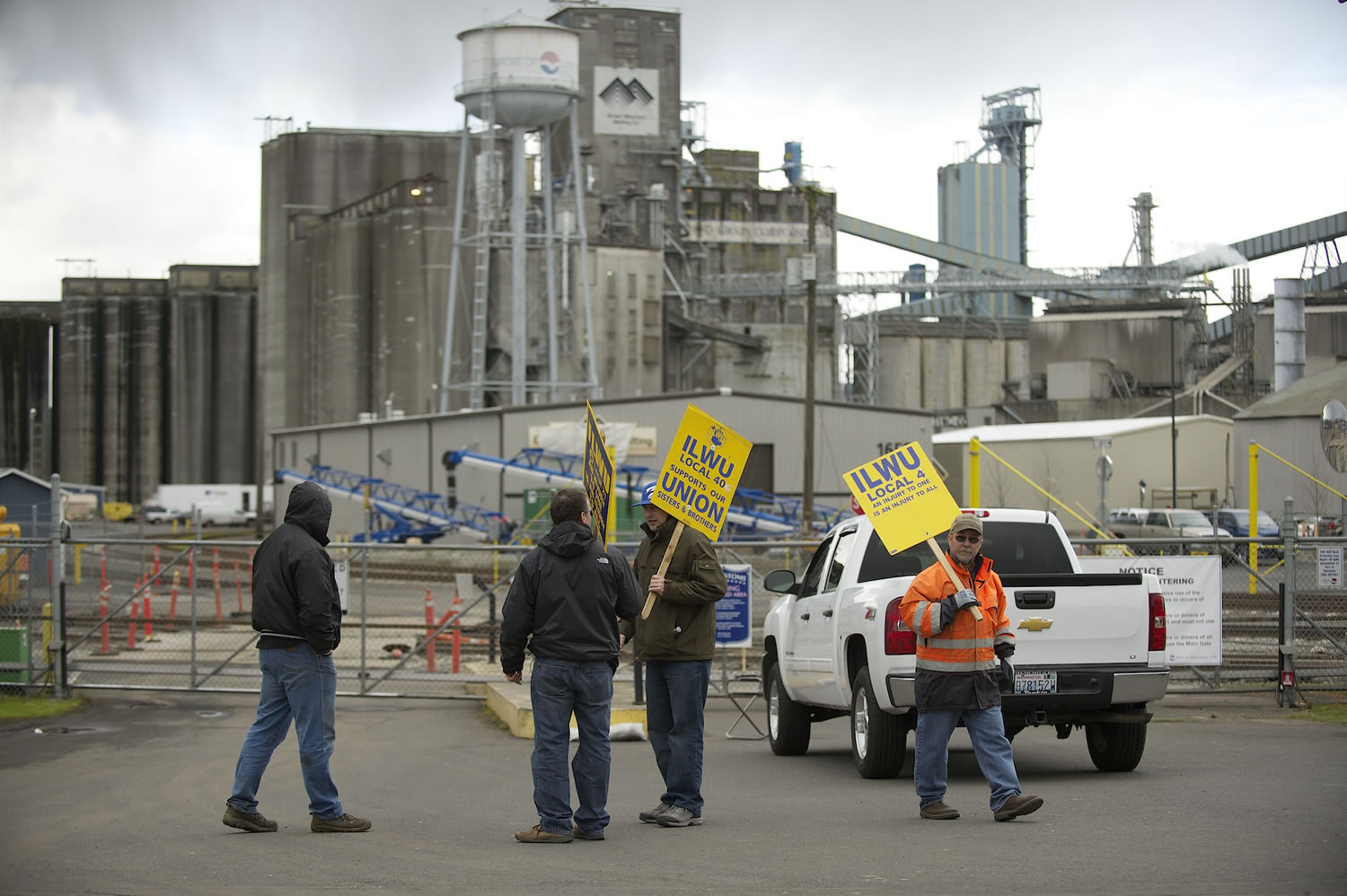 A small group representing locked out ILWU members picket outside a gate at the Port of Vancouver on Wednesday in Vancouver.