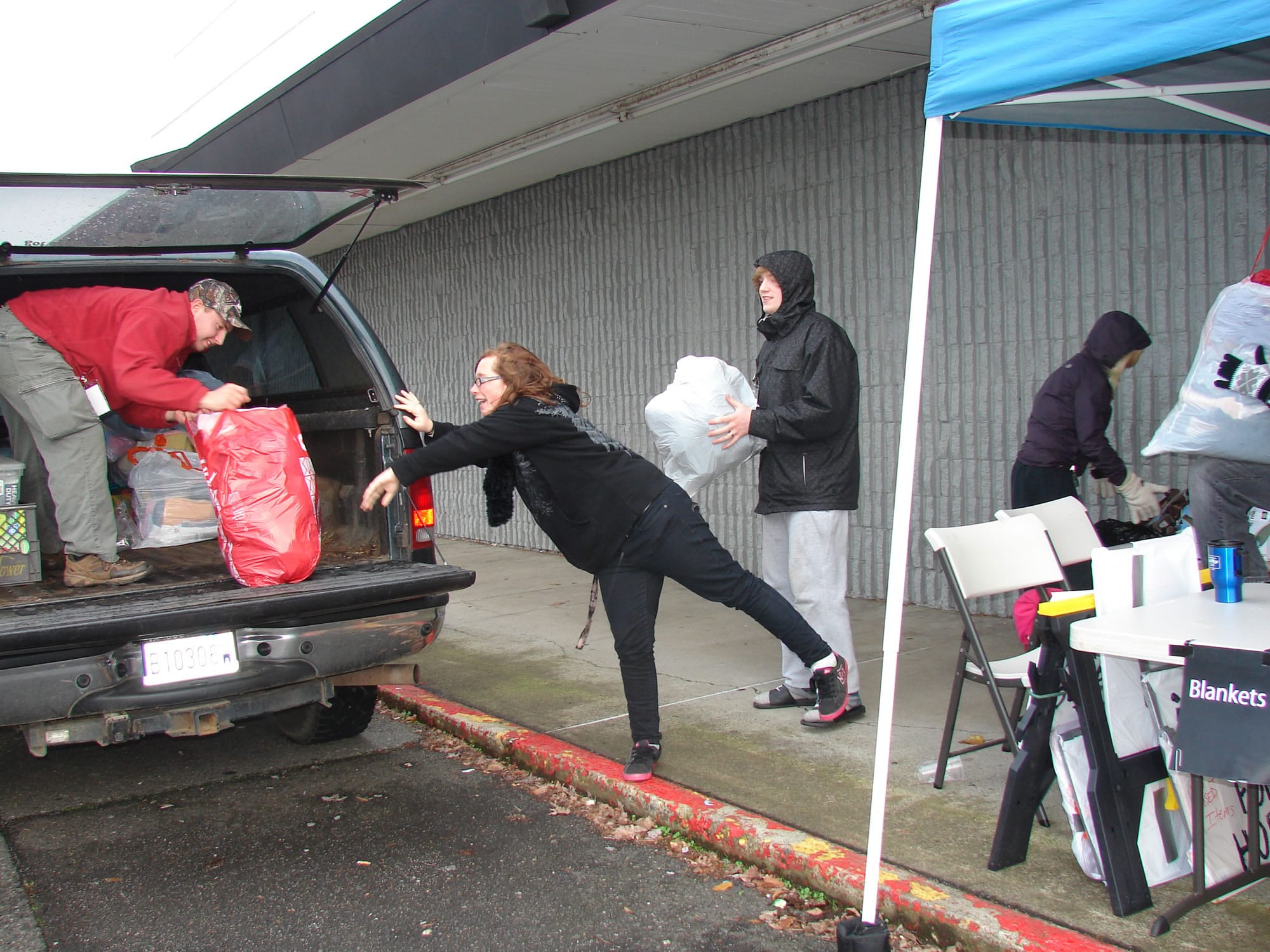 Ogden: Brandon Snow-Kanniainen, from left, Ashley Hopkins, Manny Rocha and Sanyissa Secor load blanket and clothing donations Dec. 1 at Living Hope Church, 2711 N.E.