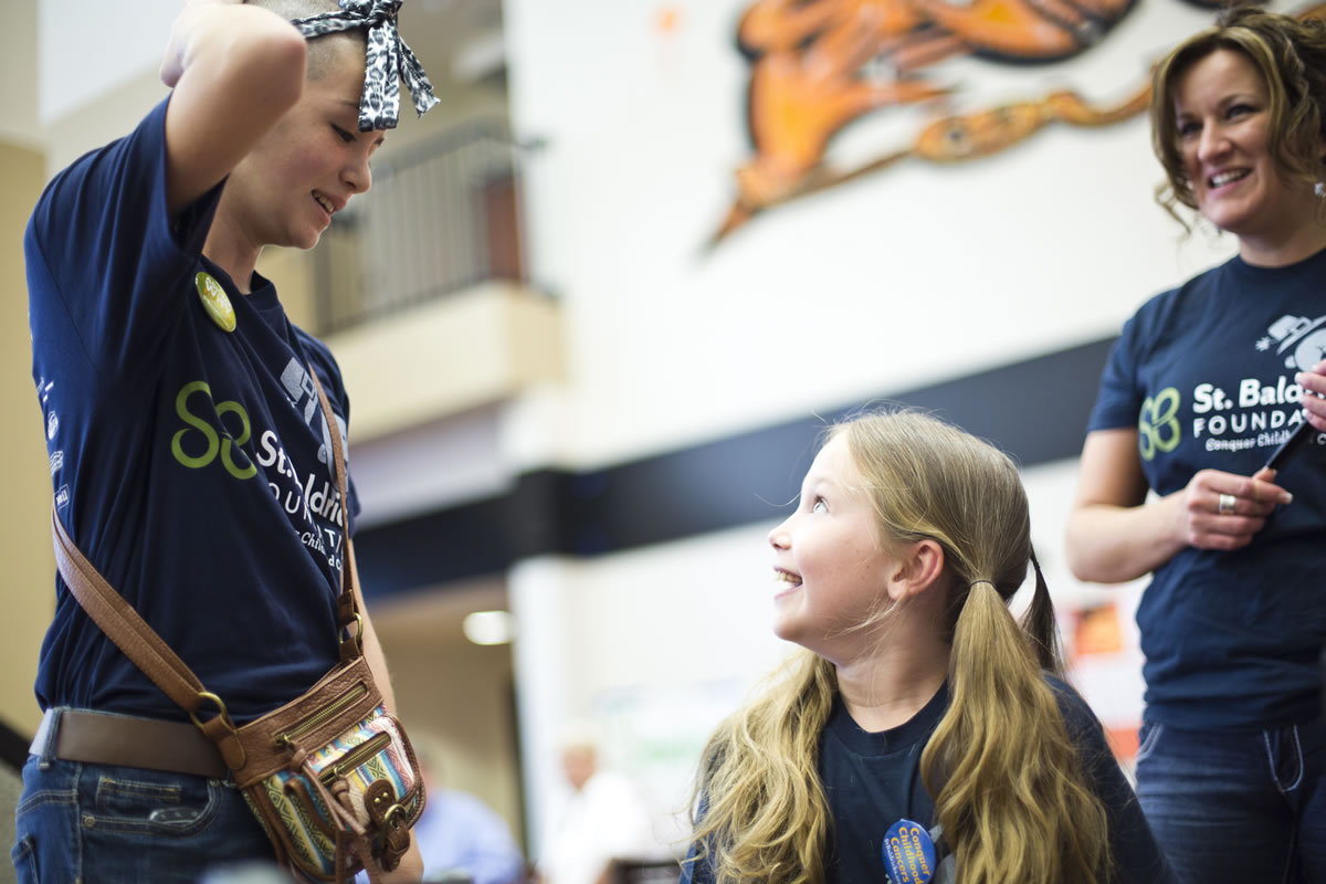 Before the big shave, Sammy Mederos, right, talks with Hannah Van Every, left, who had her head shaved the day before at a Portland fundraiser for St.