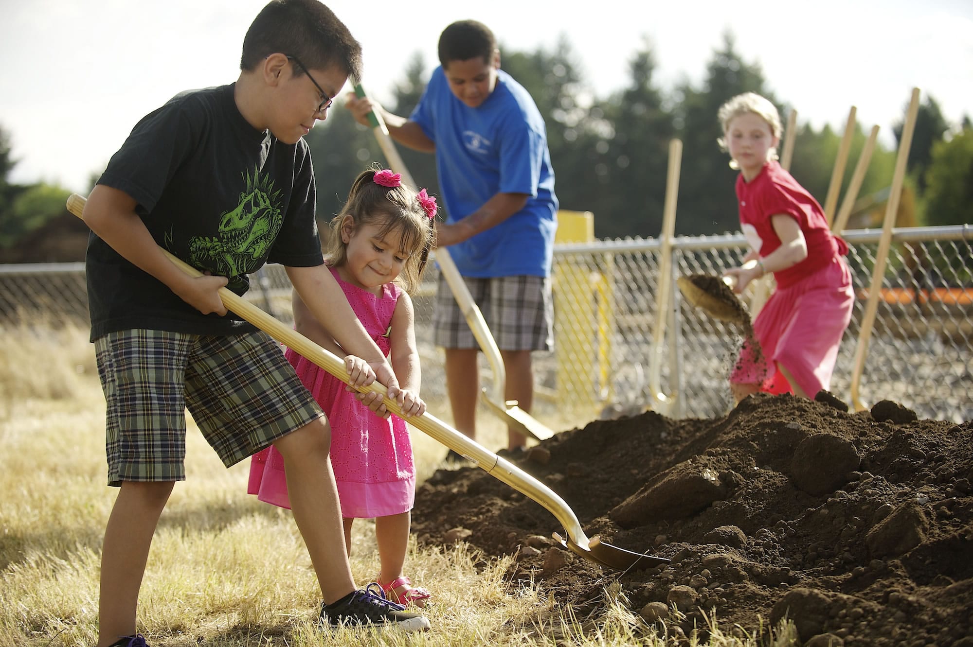 Using a gold shovel, Edvin Elguea, 9, a fourth-grader at Crestline Elementary School, helps his sister, Naobe, 2, shovel ceremonial dirt during the official groundbreaking at the construction site of the new Crestline Elementary School.