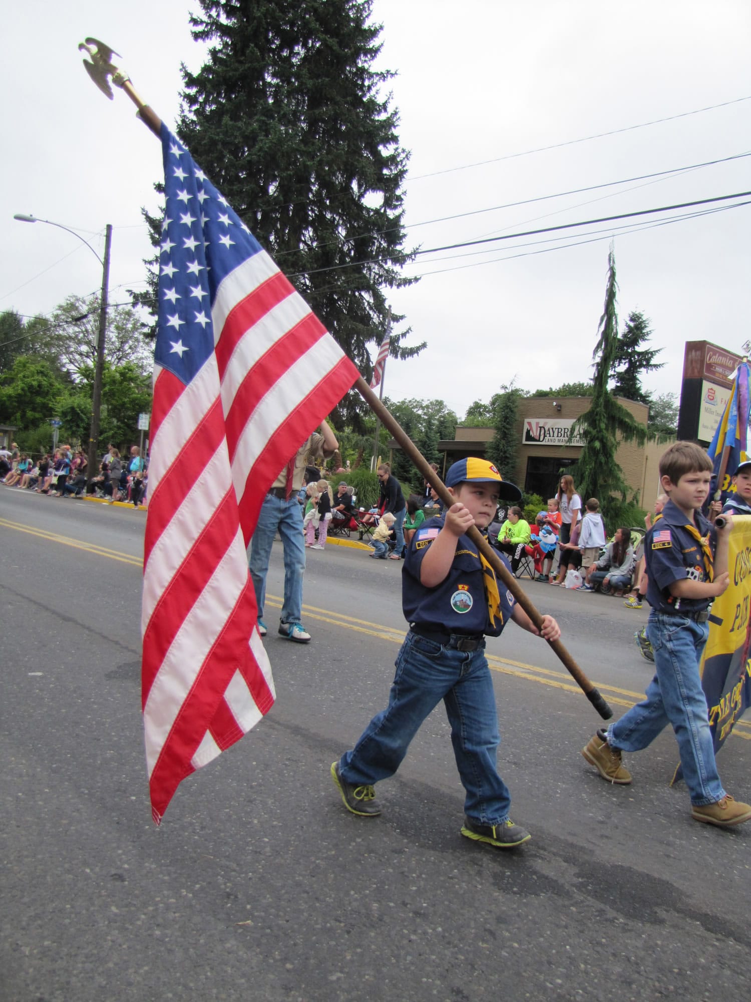 Stefanie Donahue/The Columbian 
 Devon Walker, 7, carries the American flag at the Harvest Days parade on Saturday. &quot;He is very proud,&quot; said his mother Amber Walker, as she walked along. Devon is a part of Cub Scout Pack 443.