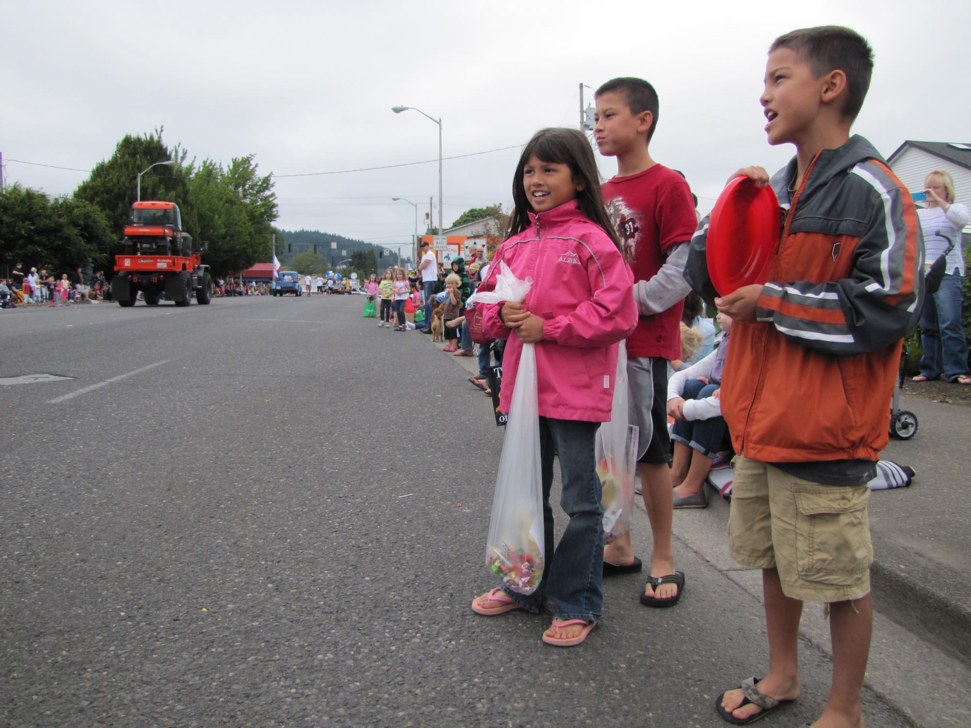 From left, Kendra, Richie and Tommy Azbill wait for candy at the Harvest Days parade July 20.