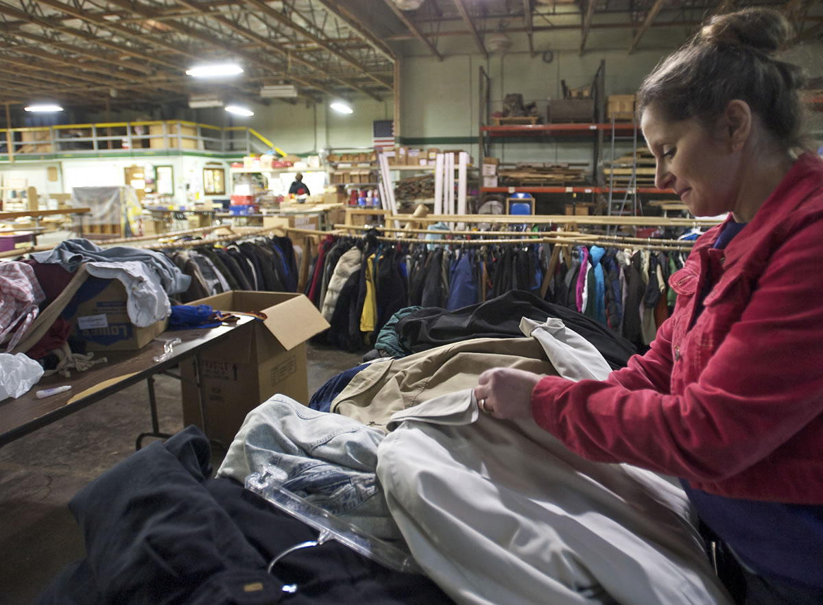 Cheryl Payne, a volunteer staff member with Friends of the Carpenter, sorts donated coats and jackets that were collected by local Boy Scouts.