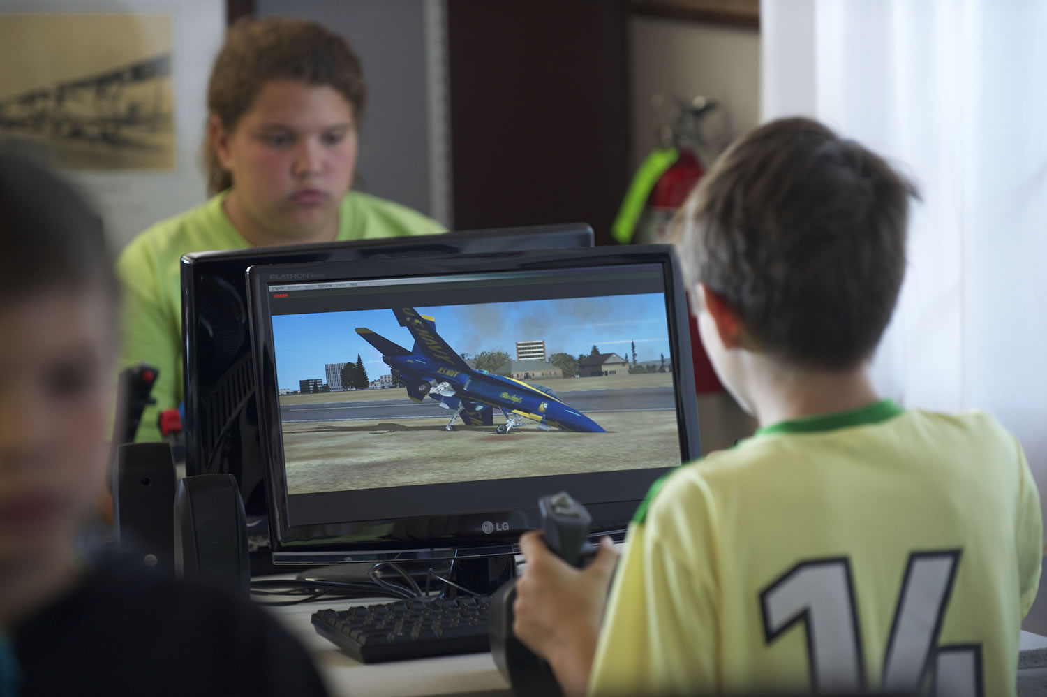 Children play on computer flight simulators at Pearson Field Education Center's Open Cockpit Day on Saturday.