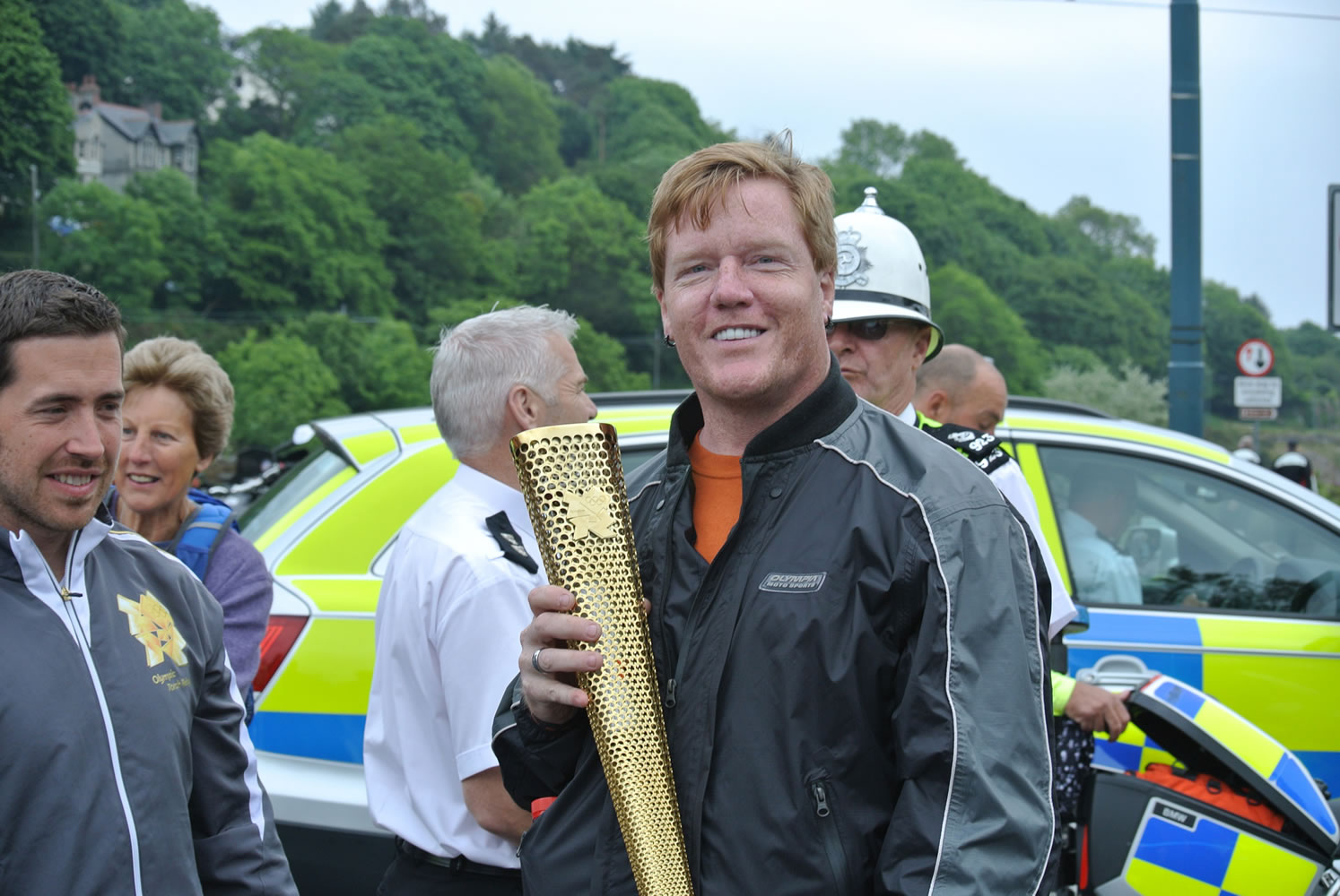 Drew Colburn holds the Olympic torch on the Isle of Man in June.