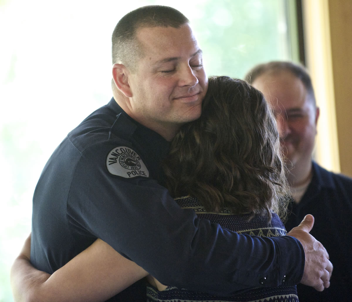 Vancouver police Officer Eric McCaleb gets a hug from Heidi Stewart, 18, after he received the Life Saving Award during a ceremony Thursday.