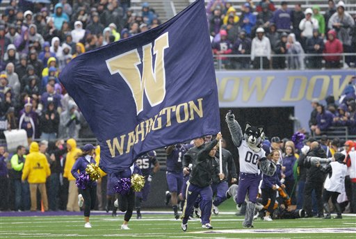 The University of Washington football team runs onto the field at Husky Stadium before its game Saturday against Arizona.