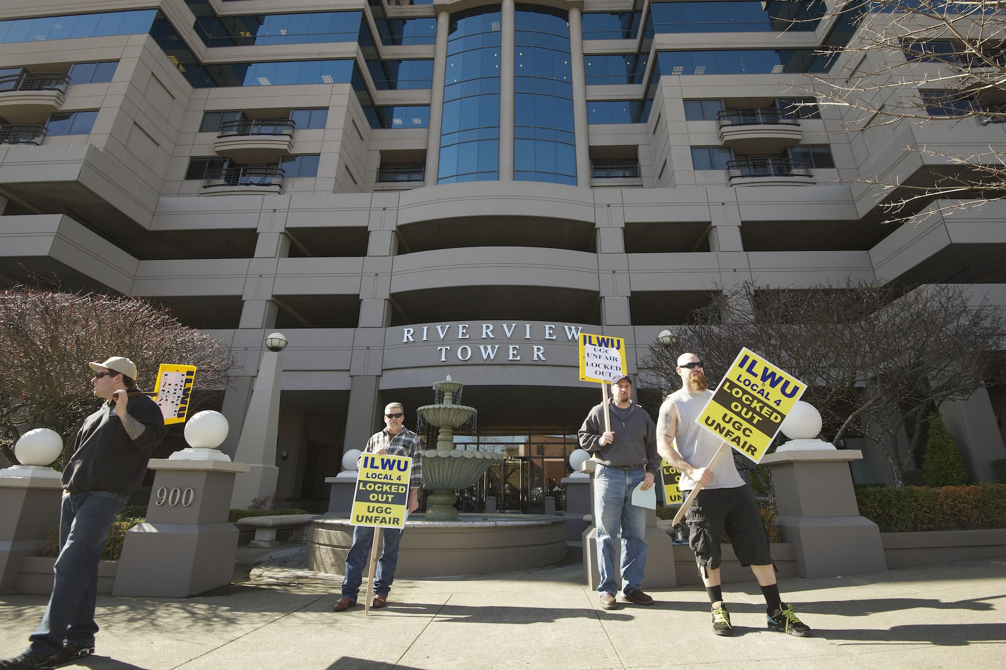 Picketers carry signs Thursday outside Riverview Tower in downtown Vancouver, where United Grain Corp.  has an office. The company locked out 44 International Longshore and Warehouse workers on Feb.