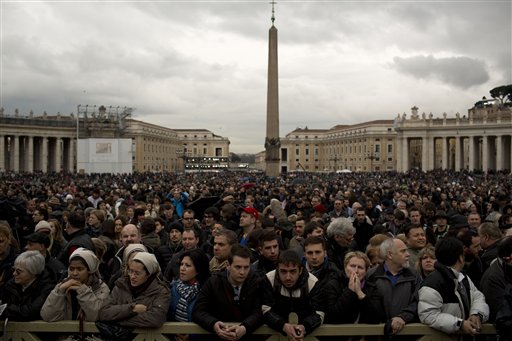Visitors wait for the chimney smoke in St. Peter's Square during the second day of the conclave to elect a new pope, at the Vatican, Wednesday, March 13, 2013.