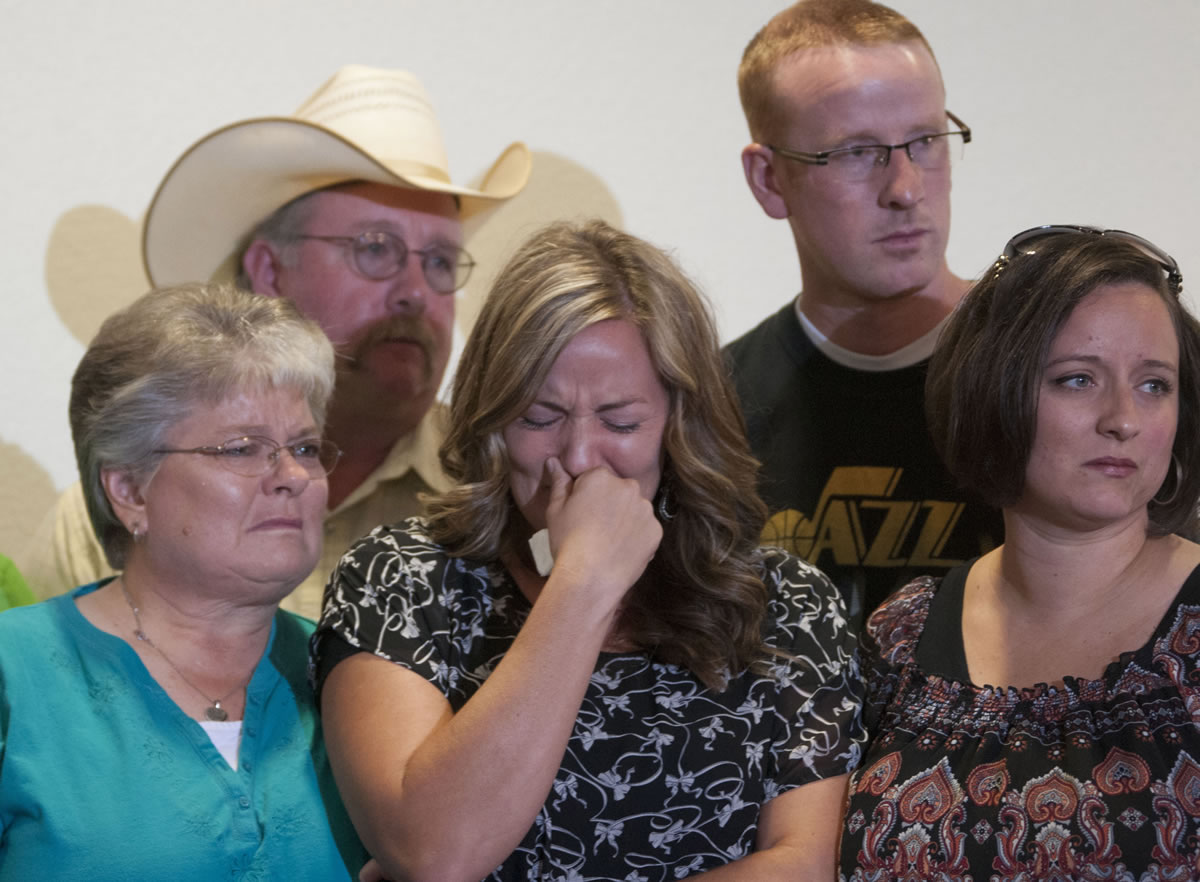 Christy Ivie, center, wife of Nicolas Ivie, holds back tears as she is surrounded by her family, her father, Tracy, and mother, DeAnn Morris, left, and her sister, Jan Cloward, right front, and brother, Travis Morris, right back, during Thursday news conference about slain U.S.