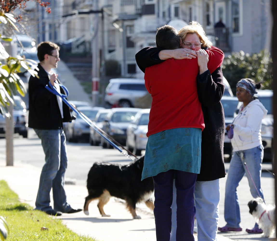 Neighbors hug outside the home of the Richard family in the Dorchester neighborhood of Boston on Tuesday.