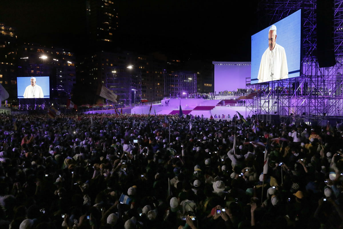 Pope Francis, seen on a giant screen, speaks to pilgrims gathered on the Copacabana beachfront Thursday in Rio de Janeiro.