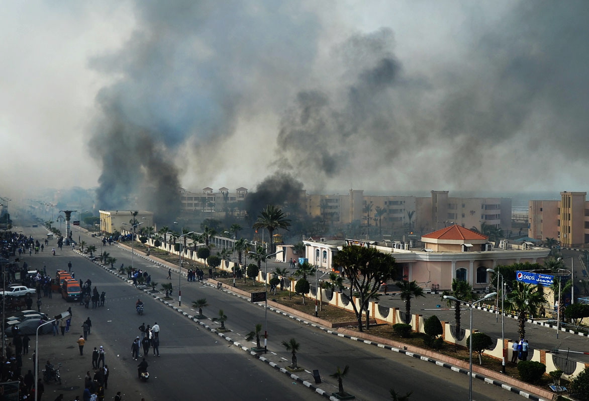 Smoke rises after Egyptian protesters clash with police, unseen, in Port Said, Egypt, Sunday, Jan. 27, 2013.  Violence erupted briefly when some in the crowd fired guns and police responded with volleys of tear gas, witnesses said. State television reported 110 were injured. Egyptian health officials say 3 have been killed in clashes between protesters and police in Port Said.