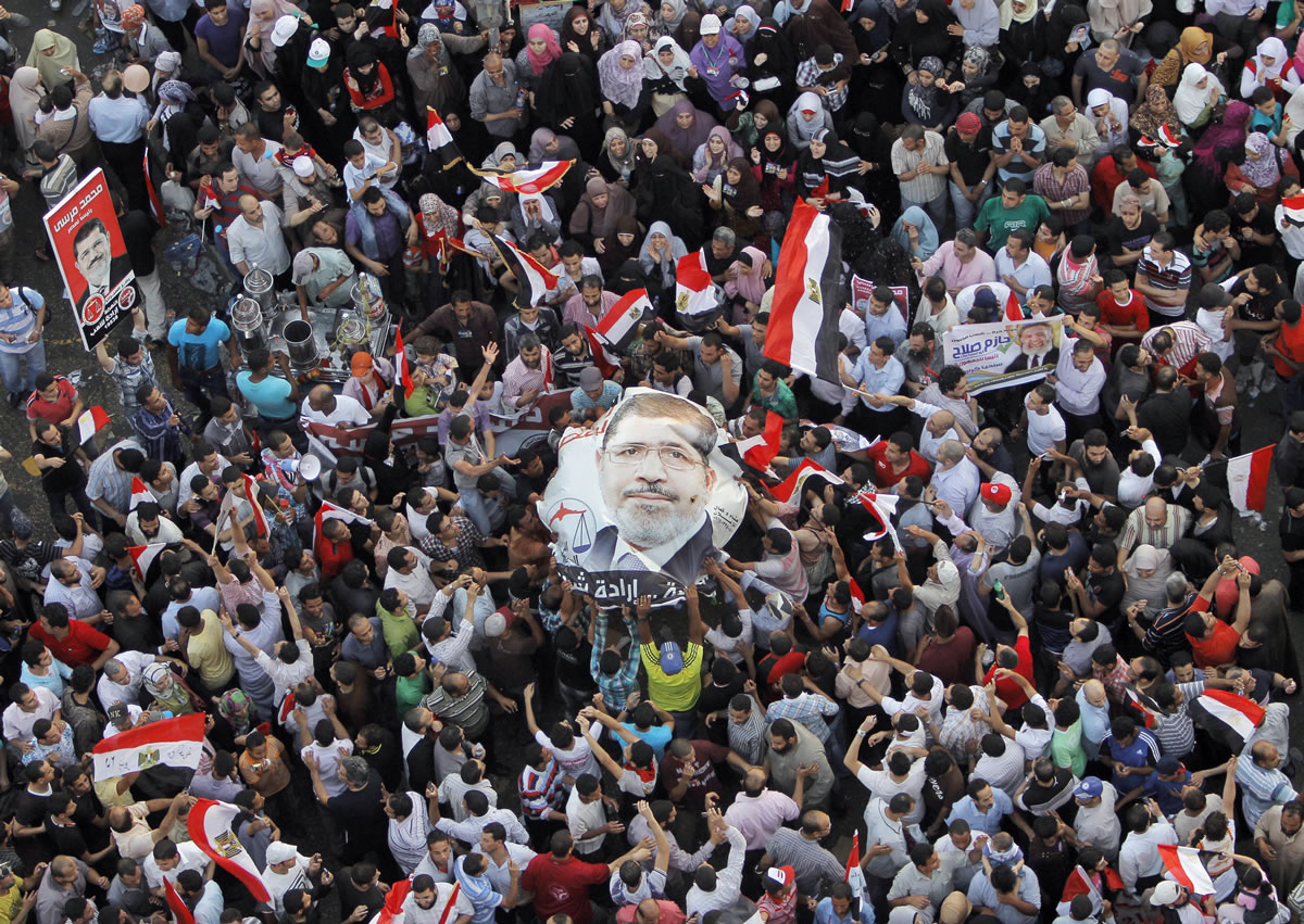 Egyptians carry a poster showing newly elected President Mohammed Morsi in Tahrir Square in Cairo, Egypt, on Sunday.