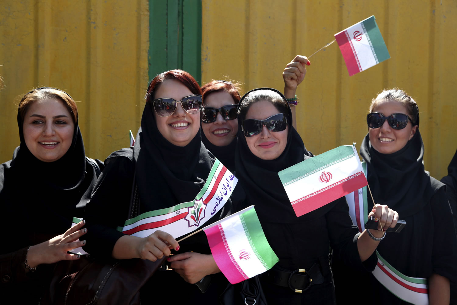 Supporters of Iranian President Hassan Rouhani wave Iranian flags upon his arrival from the U.S.
