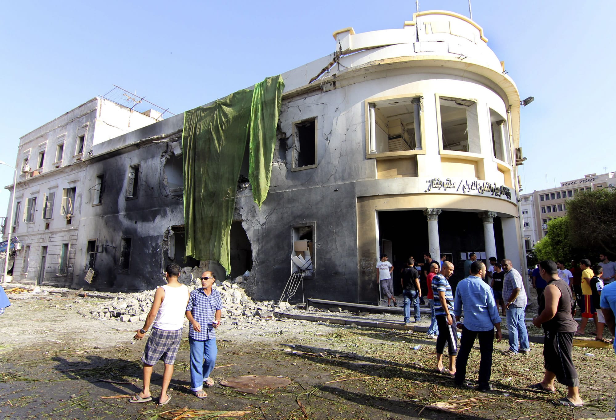 People gather to look at the site of a car bombing in Benghazi, Libya, on Wednesday.