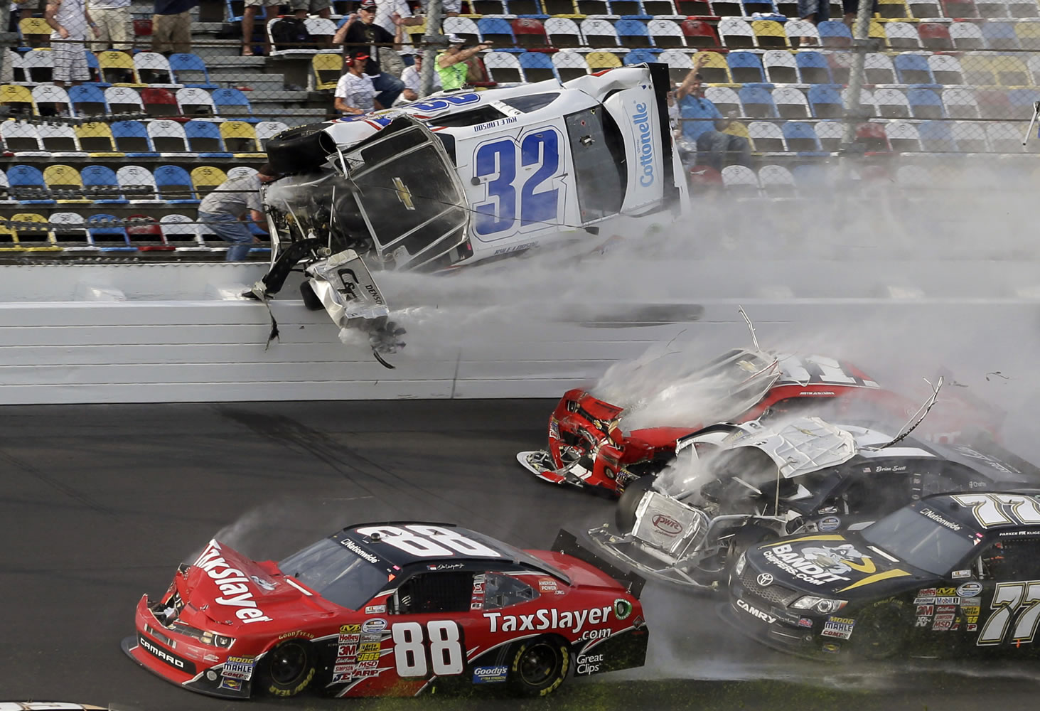 Kyle Larson (32) goes airborne and into the catch fence in a multi-car crash involving Dale Earnhardt Jr. (88), Parker Kilgerman (77), Justin Allgaier (31) and Brian Scott (2) during the final lap of the NASCAR Nationwide Series auto race at Daytona International Speedway, Saturday, Feb.