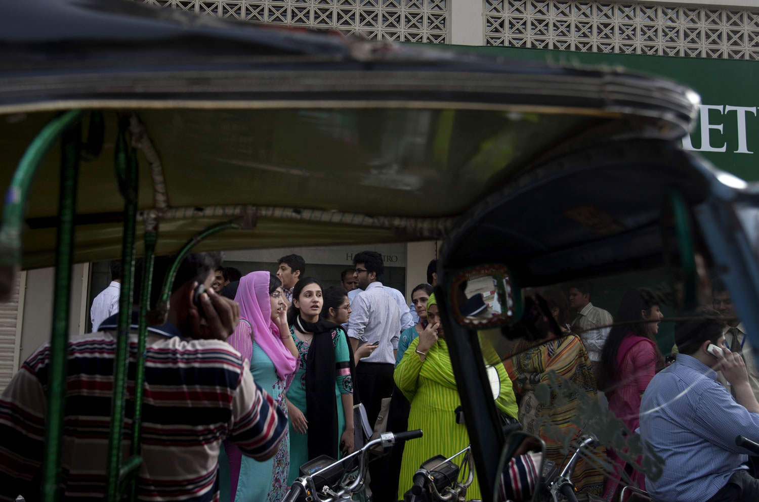 People evacuate buildings and gather on a road after a tremor of an earthquake was felt in Karachi, Pakistan, on Tuesday.