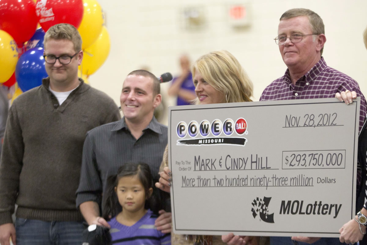 Mark and Cindy Hill hold a Powerball check with their three of their four children,  Jarod, left, Cody and six-year-old Jaiden in Dearborn, Mo., Friday, Nov. 30, 2012.