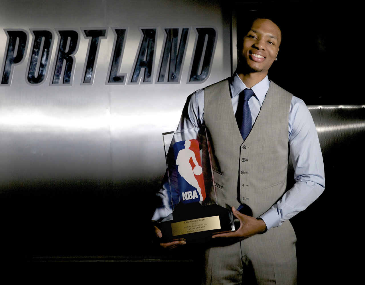 Portland Trail Blazers guard Damian Lillard poses with the trophy after being named NBA basketball's Rookie of the Year on Wednesday, May 1, 2013, in Portland, Ore. Lillard also swept all six of the league's Rookie of the Month awards this season.