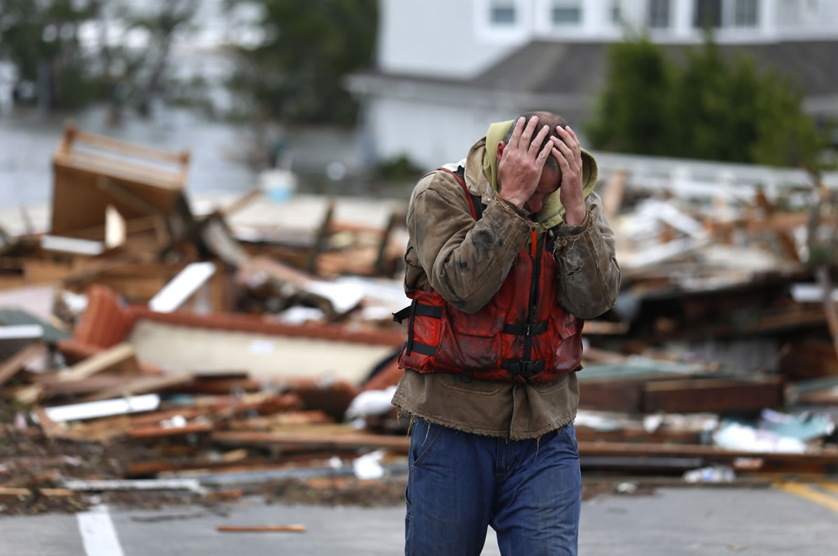 Brian Hajeski, 41, of Brick, N.J., reacts after looking at debris of a home that washed up on to the Mantoloking Bridge the morning after superstorm Sandy rolled through on Tuesday in Mantoloking, N.J.