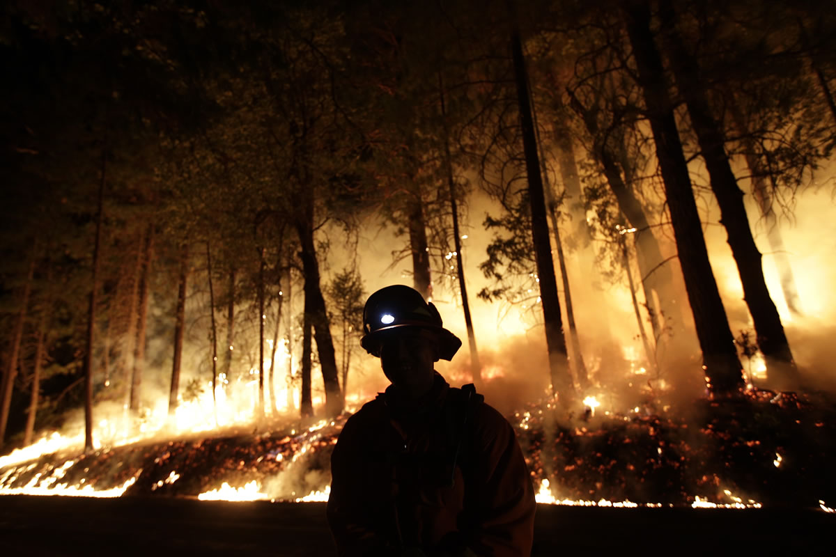 A firefighter watches for spot fires during a burnout operation while battling the Rim Fire near Yosemite National Park, Calif., on Sunday.