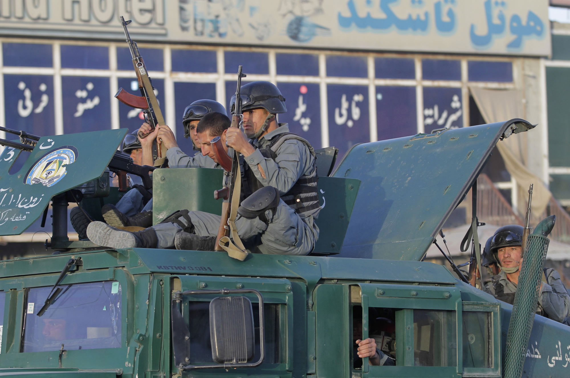 Afghan policemen sit atop a vehicle upon arrival after Taliban fighters attacked near Kabul airport, Afghanistan, on Monday.